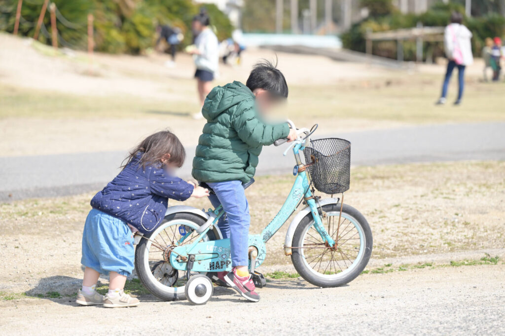 補助輪自転車に乗る兄妹