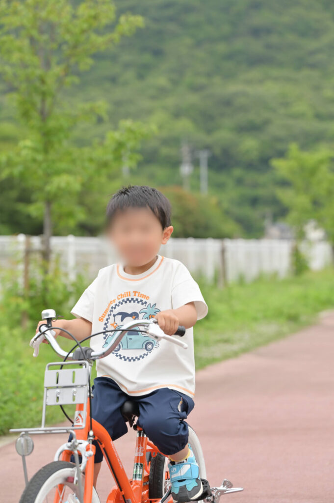 オレンジの自転車に乗るこども