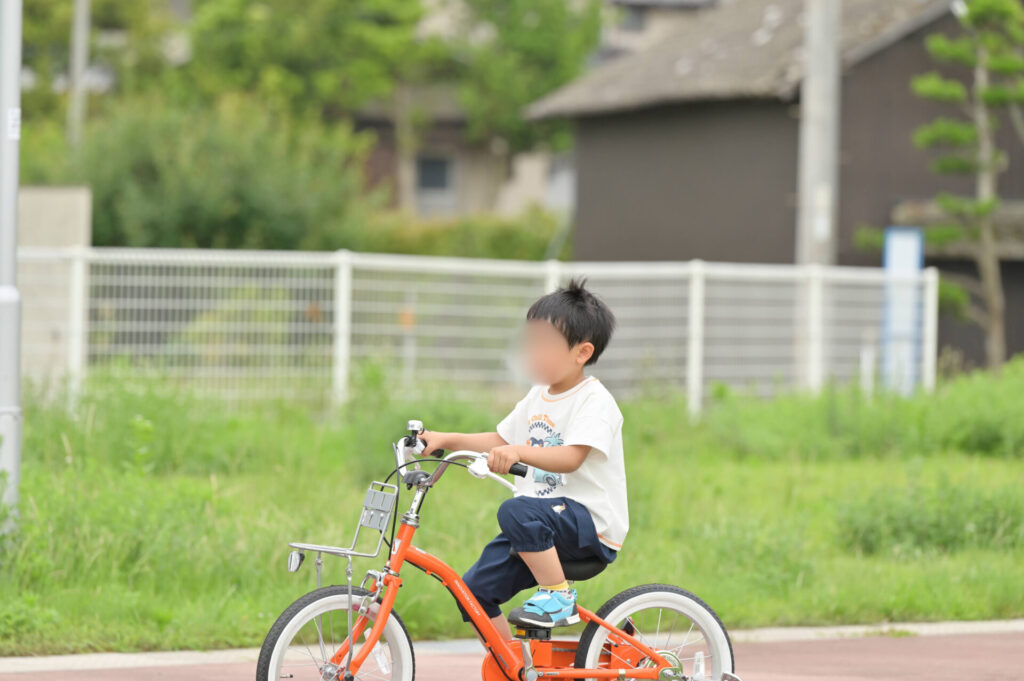 オレンジの自転車に乗るこども
