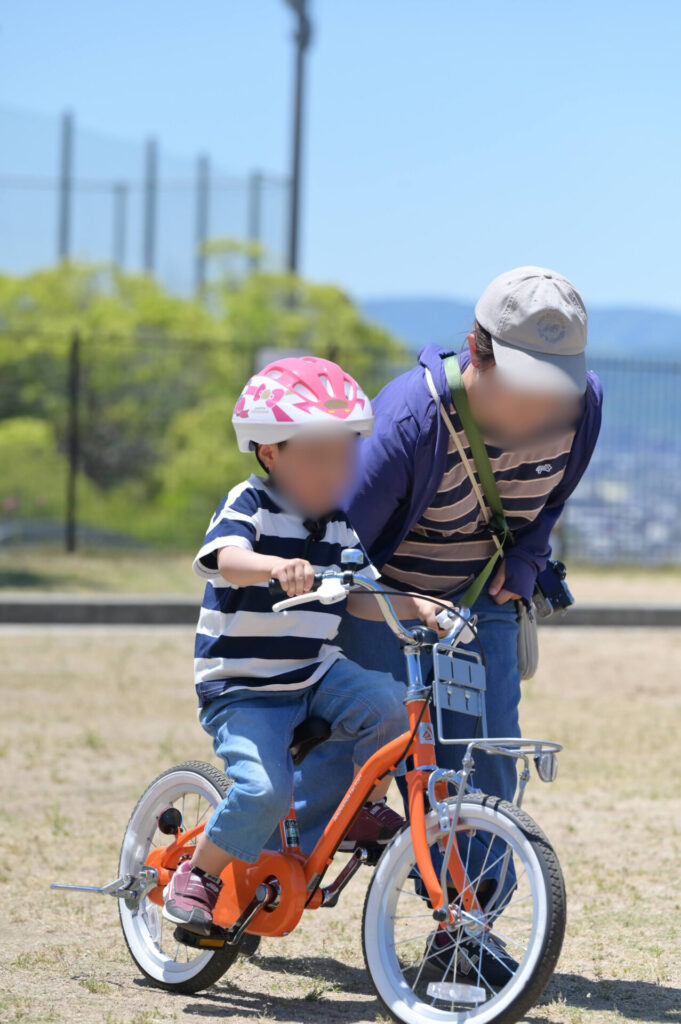 自転車の練習をする親子